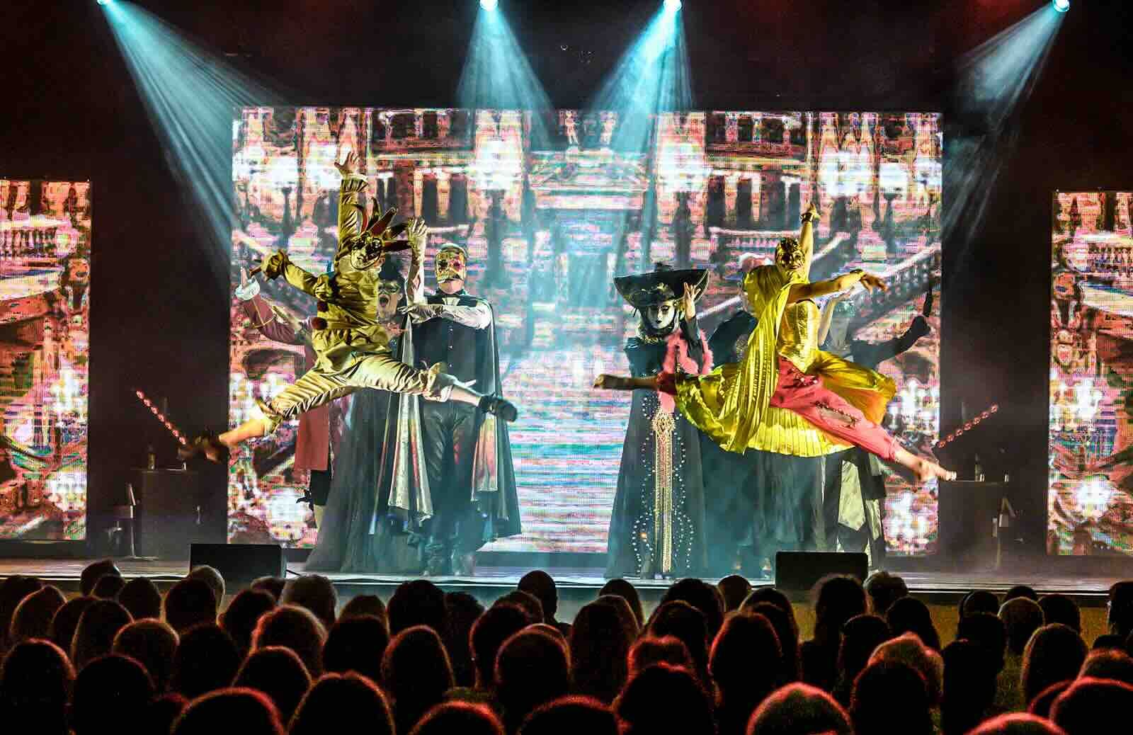 Spektakuläre Szene aus Phantom der Oper: Maskierte Tänzer, elegante Kostüme und ein eindrucksvoller Sprung inmitten mystischer Kulisse!